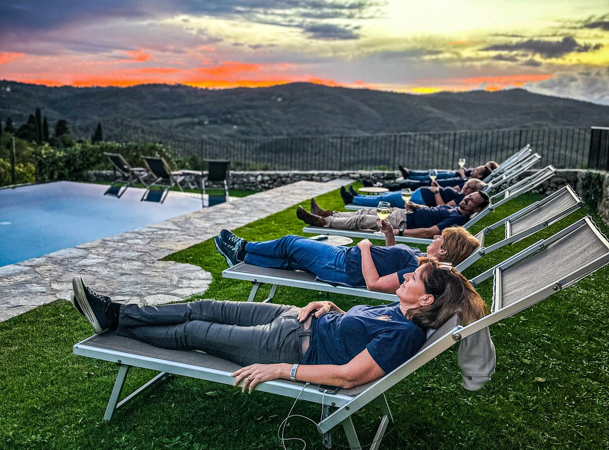 Das Team entspannt auf Liegen am Pool im Sonnenuntergang